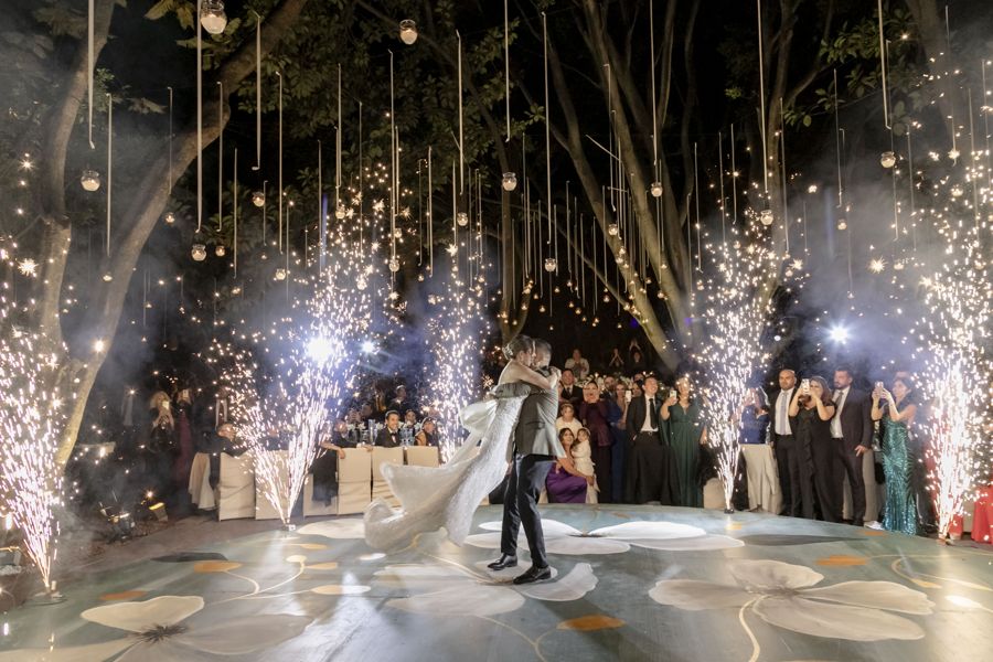 Novios bailando en la pista entre chisperos y sus invitados